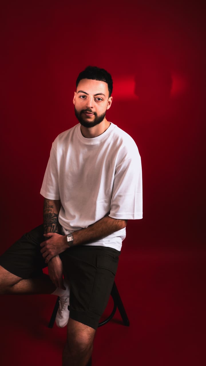 Lucas, barber et formateur, sur fond rouge